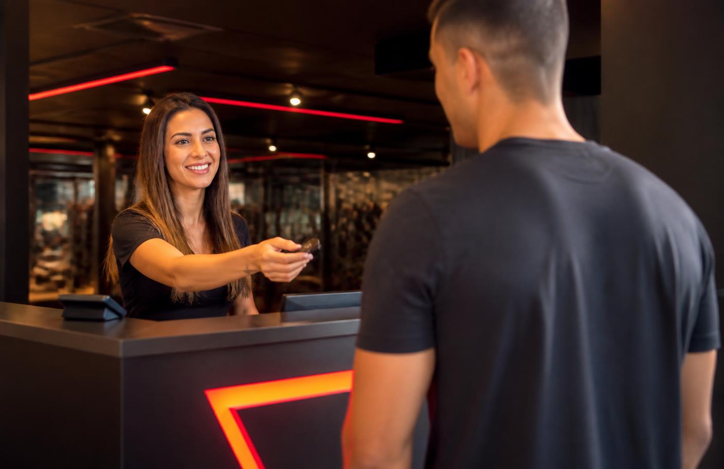 Recepcionista da Sport Fitness atendendo um aluno